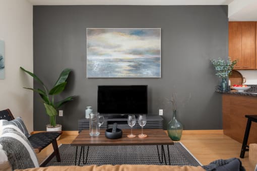 a living room with a coffee table and a television at Verge Apartments in St. Louis Park, MN