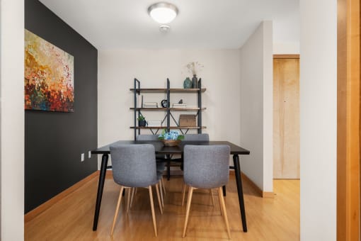 a dining room with a table and chairs and a black wall at Verge Apartments in St. Louis Park, MN