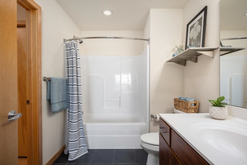 a bathroom with a shower and a sink and a toilet at Verge Apartments in St. Louis Park, MN