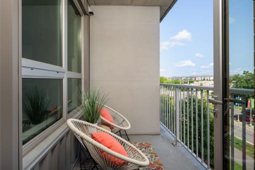 a balcony with two chairs and a view of the city at Verge Apartments in St. Louis Park, MN
