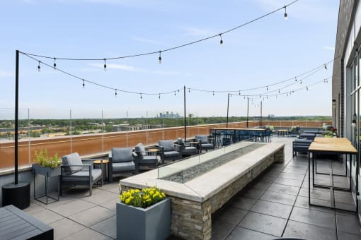 the rooftop terrace at the envoy hotel has seating and a view of the city at Verge Apartments in St. Louis Park, MN
