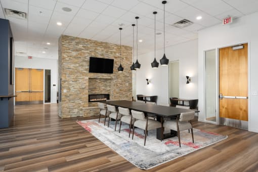 a dining room with a table and chairs and a fireplace at Verge Apartments in St. Louis Park, MN