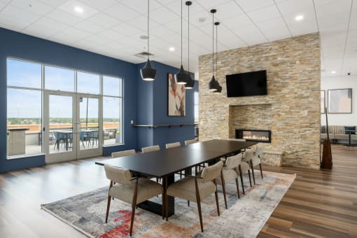 a dining room with a table and chairs and a fireplace at Verge Apartments in St. Louis Park, MN