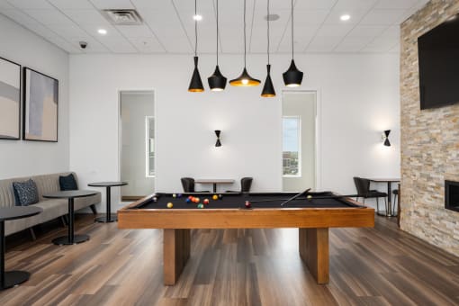 a games room with a pool table and a tv at Verge Apartments in St. Louis Park, MN