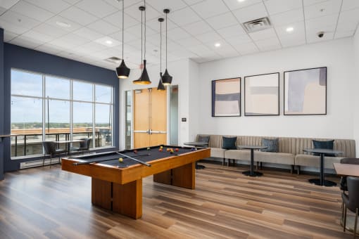 an open room with a pool table and couches at Verge Apartments in St. Louis Park, MN