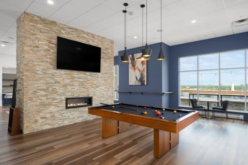 a games room with a pool table and a fireplace at Verge Apartments in St. Louis Park, MN