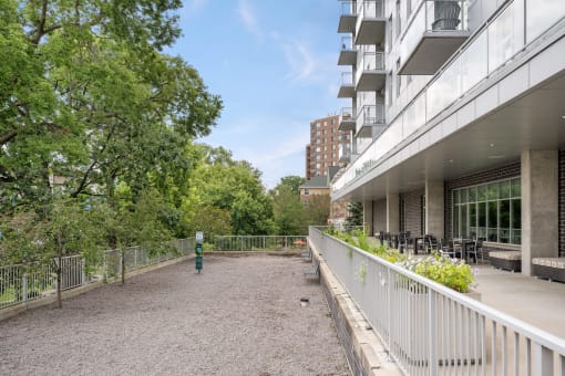 the patio of a building with a fence and trees at Verge Apartments in St. Louis Park, MN