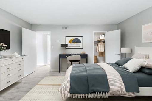 A bedroom with a bed, desk, and chair.