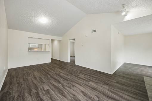 A room with wooden flooring and white walls.