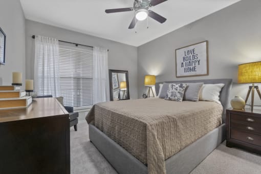 Bedroom with ceiling fan, large window, and carpet