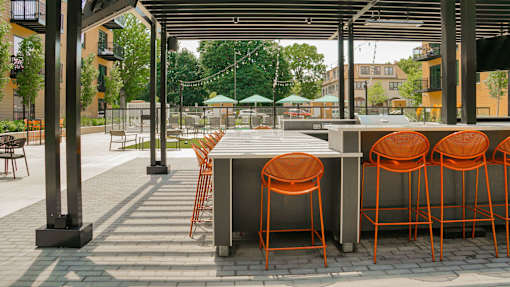 A patio with orange chairs and a table.