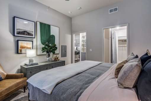 A bedroom with a large bed and a mirror on the wall.
