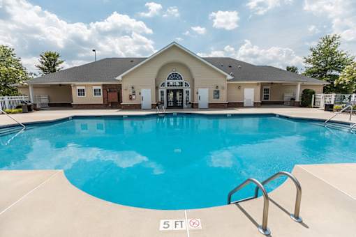 A large swimming pool in front of a building with a sign that says 5 ft.
