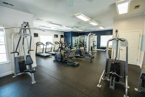 A gym with a variety of equipment including a leg press machine.