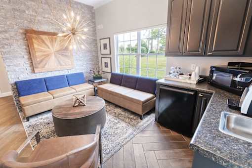 A kitchen with a blue couch and a wooden table.