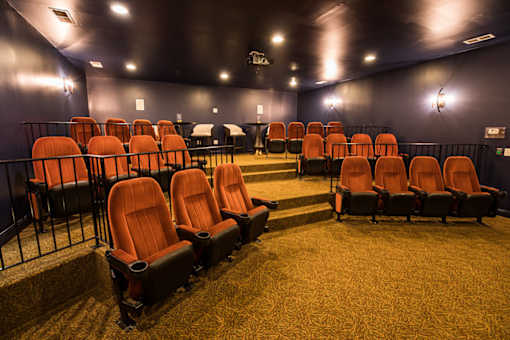 A row of orange seats in a dark room.