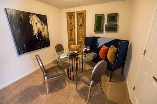 A living room with a black and white painting on the wall.