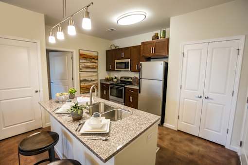 A kitchen with a granite countertop and a refrigerator.