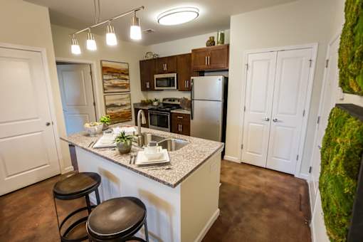 A kitchen with a white counter top and brown stools.