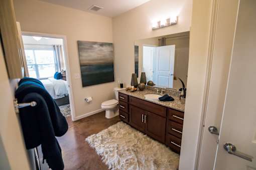 A bathroom with a toilet, sink, and mirror.