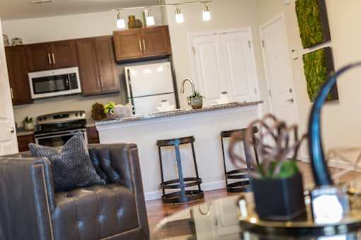 A modern kitchen with a black leather chair and a white fridge.