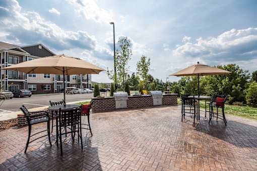 A patio with a table and chairs under umbrellas.