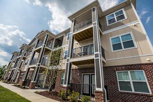 A multi-story apartment building with balconies and windows.