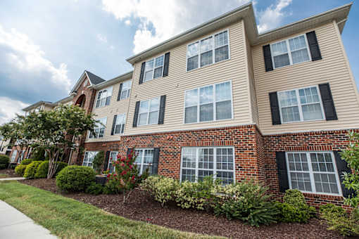 A multi-story residential building with a brick facade and black shutters.