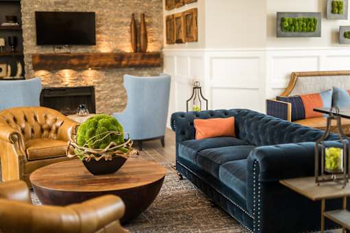 A living room with a blue couch and a fireplace.