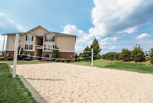 A sandy area in front of a two-story building.