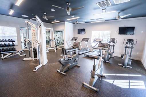 A spacious gym with a variety of equipment including treadmills, weights, and exercise machines.