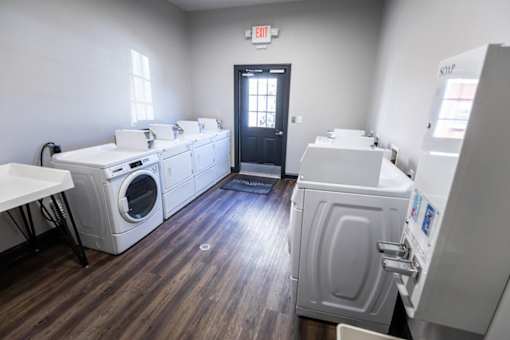 A laundry room with a black door and a white washing machine.