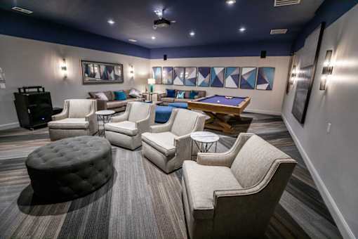 A room with a pool table and a variety of seating options.