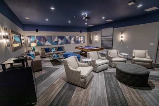 A modern living room with a pool table and comfortable seating.