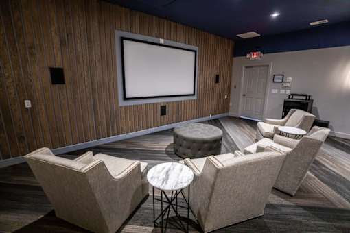 A room with a screen and chairs.