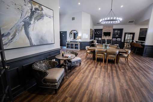 A large room with a wooden floor and a painting on the wall.