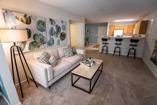 A living room with a white couch and a lamp.