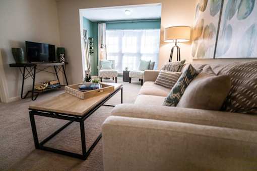 A living room with a couch, coffee table, and television.