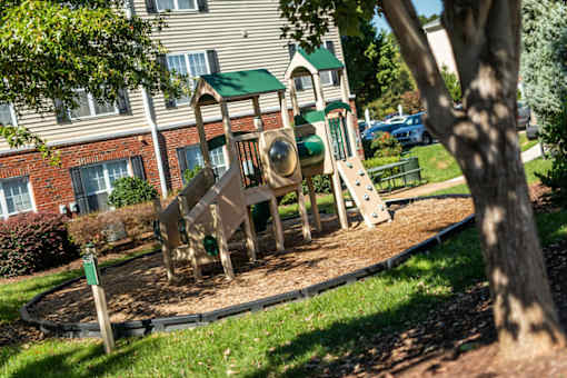 A playground with a slide and a green roof.
