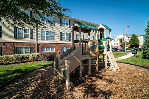 A playground with a slide and a green roof.