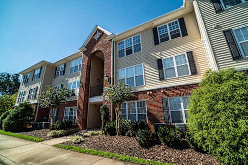 A row of apartment buildings with a clear blue sky above.