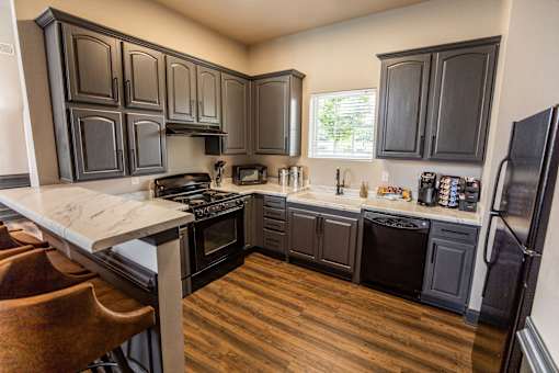 A kitchen with black cabinets and a white counter top.