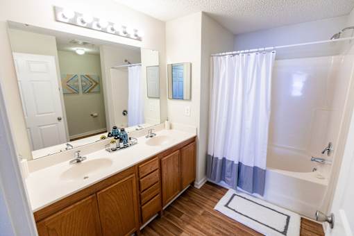 A bathroom with a white sink and a white tub.