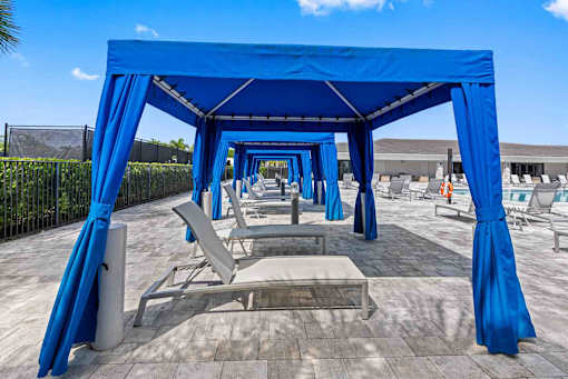 a row of blue shade structures with tables and chairs