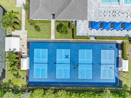 a birds eye view of the pool of a house with a tennis court