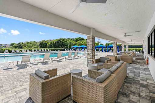 a pool with lounge chairs and tables at a resort