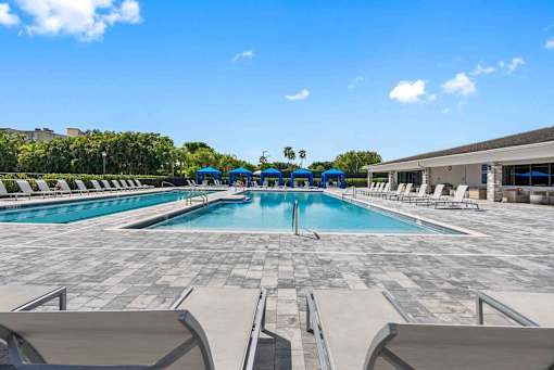 a swimming pool with chairs and umbrellas at the resort