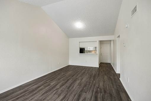A room with wooden flooring and white walls.