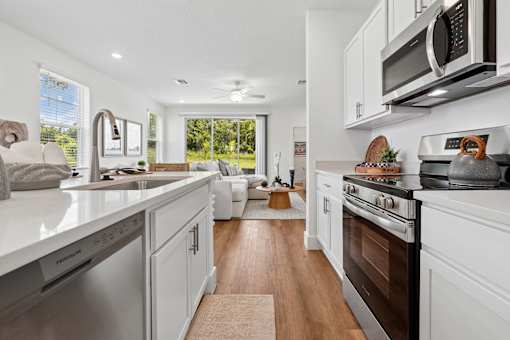 A modern kitchen with white cabinets and stainless steel appliances.