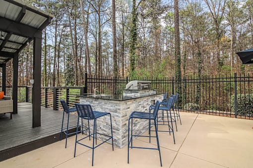 A patio with a table and chairs and a fence.
